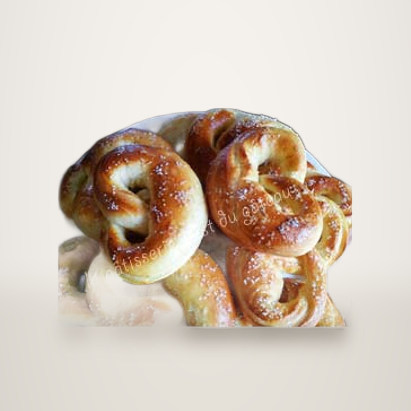 Bretzels dorés au gros sel sur une assiette blanche.