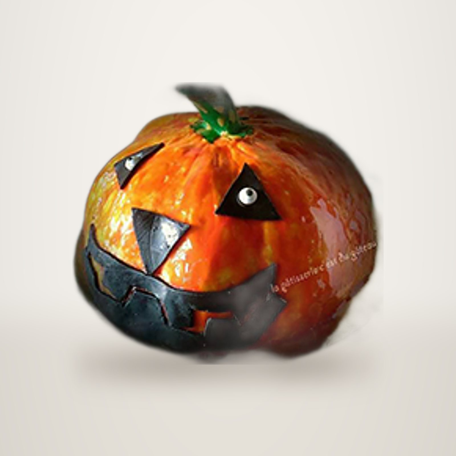 Gâteau d'Halloween en forme de citrouille, avec un visage souriant.