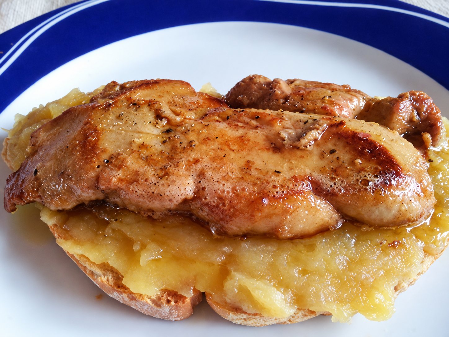Escalope de foie gras poêlée sur une compotée de pommes et du pain grillé.