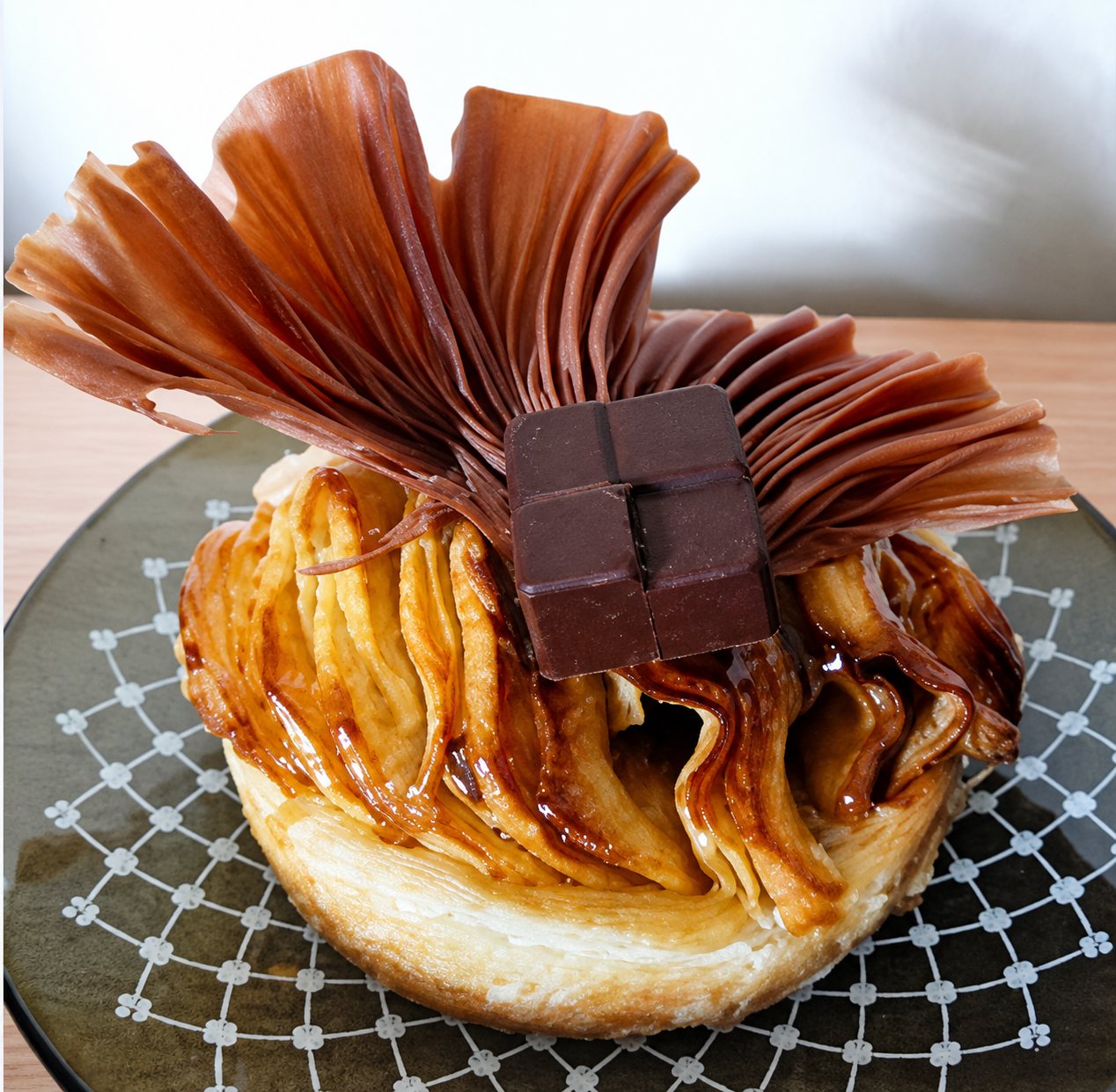 Pâtisserie individuelle au caramel et au chocolat, coiffée d'un éventail croustillant.