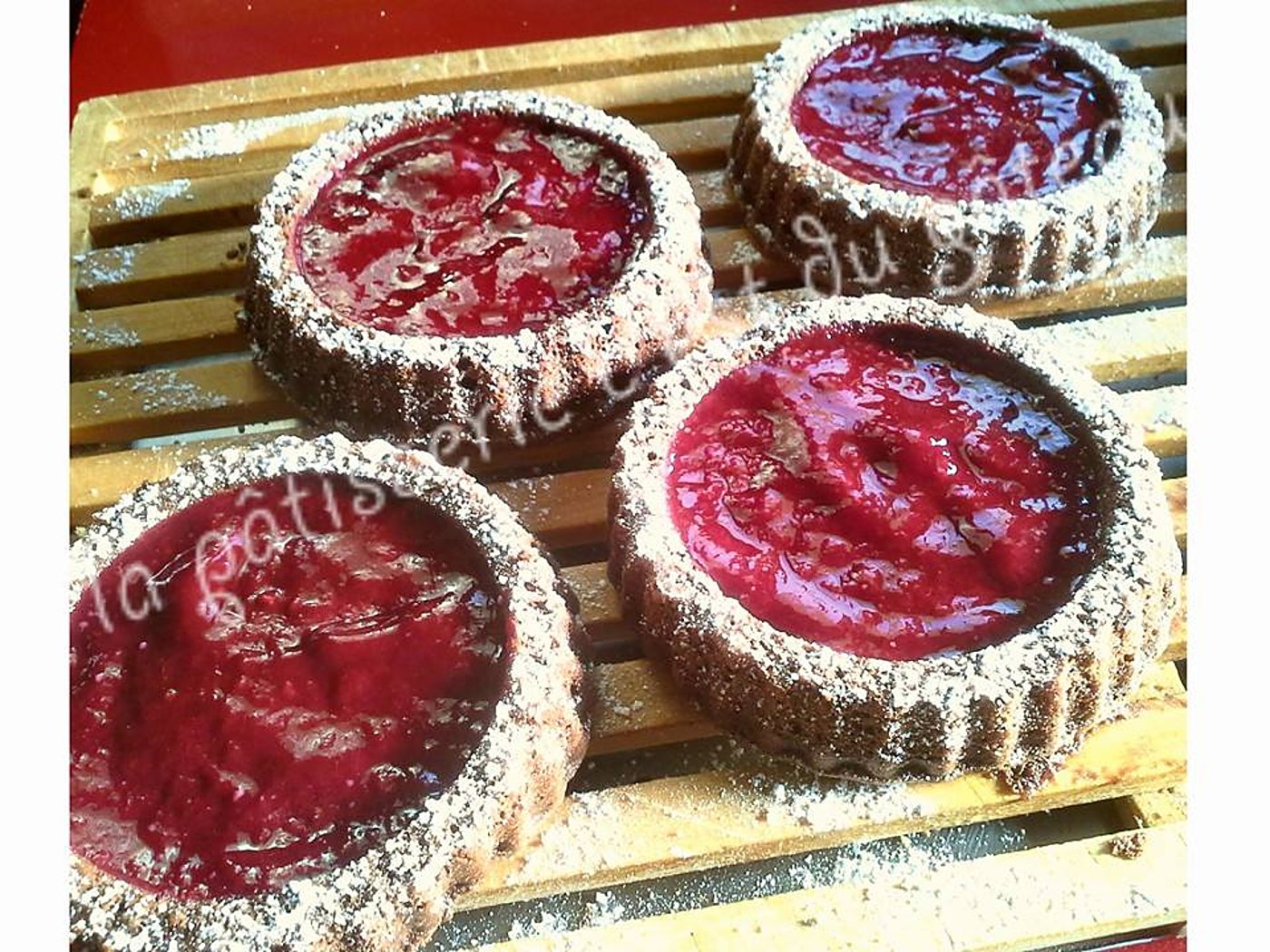 Moelleux au chocolat servis avec un coulis de fruits rouges et du sucre glace.